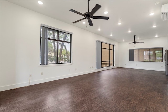 spare room with dark wood-type flooring, ceiling fan, and an AC wall unit