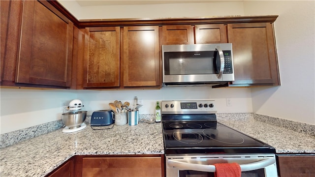 kitchen featuring light stone countertops and stainless steel appliances