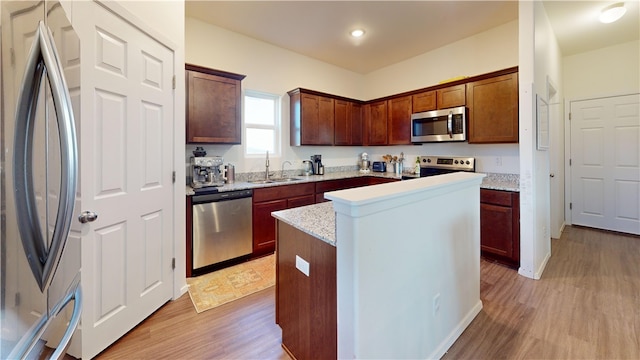 kitchen featuring sink, a kitchen island, light hardwood / wood-style floors, and appliances with stainless steel finishes