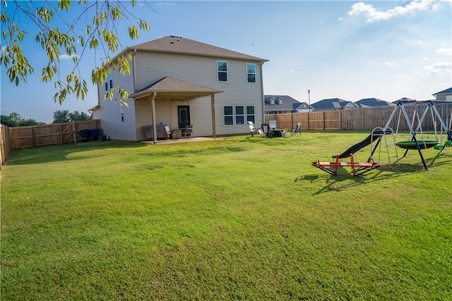 back of house featuring a playground and a yard