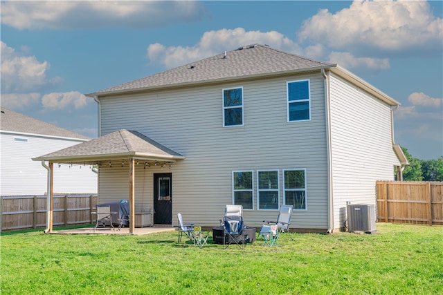 back of property with cooling unit, a patio area, and a yard