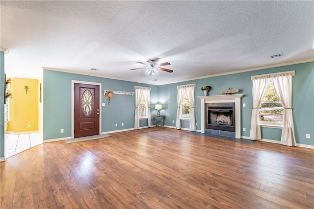 unfurnished living room with ceiling fan, crown molding, hardwood / wood-style floors, and a textured ceiling