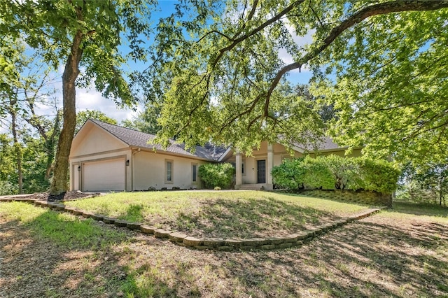 view of front of home with a garage and a front lawn