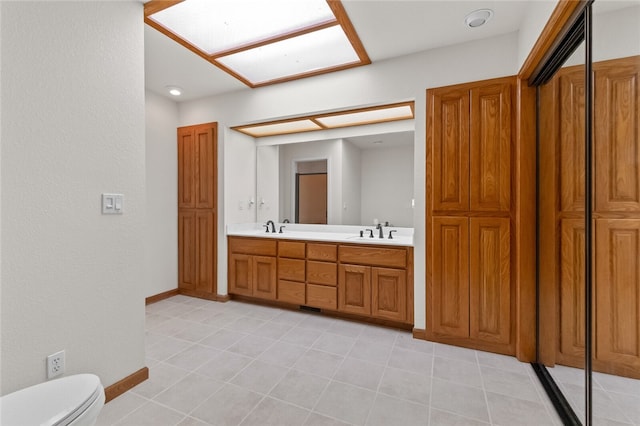 bathroom featuring a skylight, vanity, and toilet