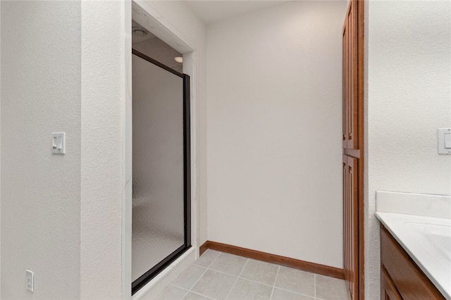 bathroom featuring tile patterned flooring, an enclosed shower, and vanity