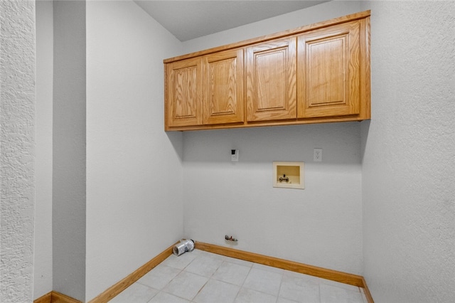 washroom with hookup for a washing machine, light tile patterned floors, and cabinets