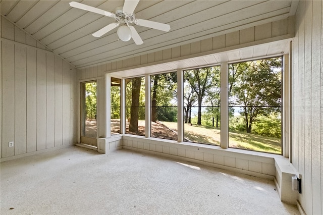 unfurnished sunroom with ceiling fan, wood ceiling, vaulted ceiling, and a healthy amount of sunlight