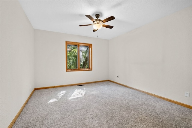 spare room featuring ceiling fan and carpet