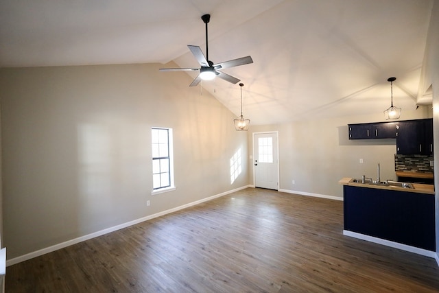 unfurnished living room with ceiling fan, sink, dark hardwood / wood-style floors, and lofted ceiling