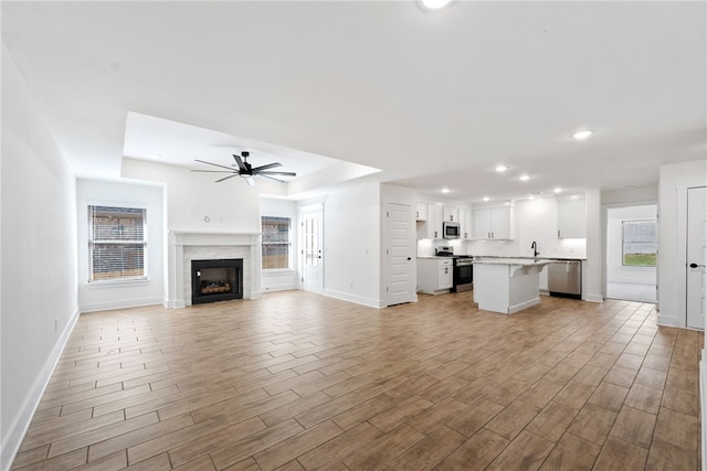 4206 SW Adams St, Bentonville, AR 72713 - unfurnished living room featuring a ceiling fan, a fireplace, recessed lighting, baseboards, and light wood-style floors