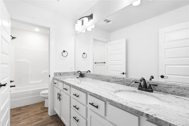 full bathroom with wood-type flooring, shower / washtub combination, vanity, and toilet