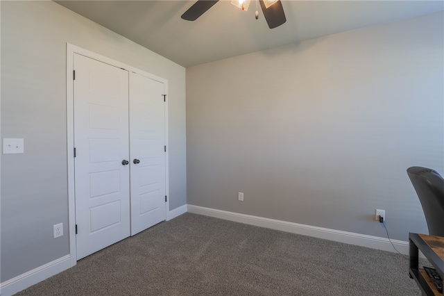 interior space featuring dark carpet and ceiling fan