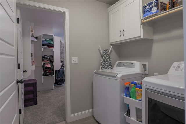 clothes washing area featuring independent washer and dryer, cabinets, and light carpet