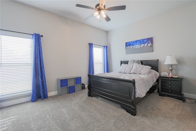 carpeted bedroom featuring ceiling fan and multiple windows