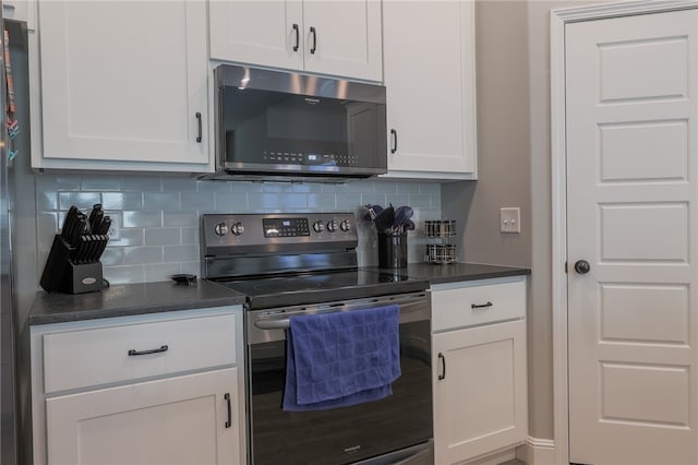 kitchen with tasteful backsplash, white cabinets, and appliances with stainless steel finishes