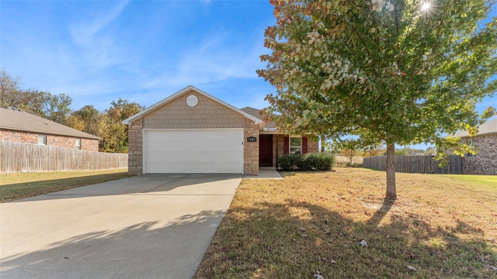 view of front of property featuring a front yard and a garage