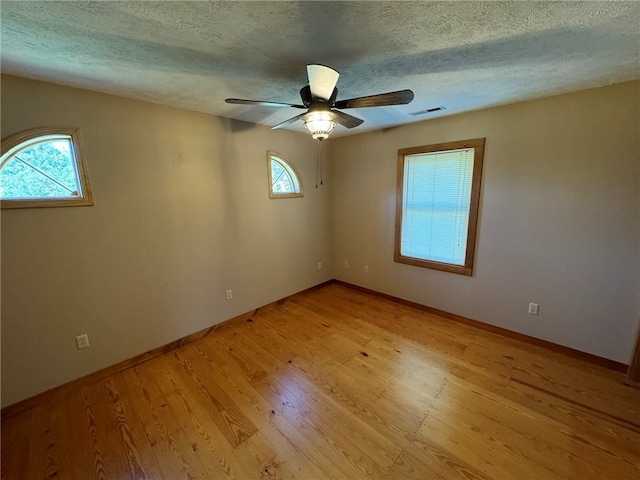 unfurnished room featuring ceiling fan, a textured ceiling, and light hardwood / wood-style flooring