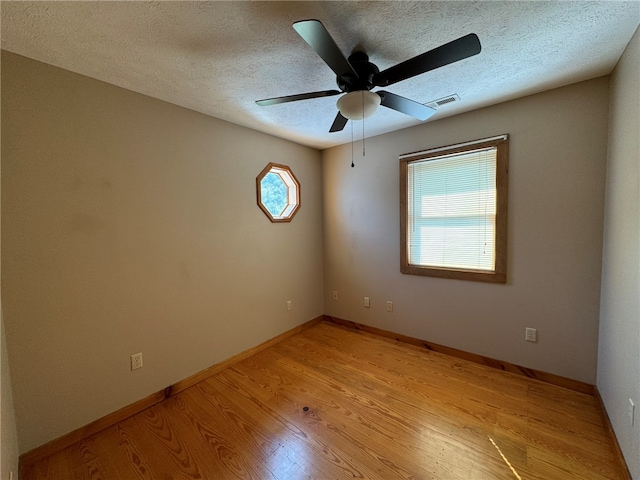 unfurnished room featuring a textured ceiling, plenty of natural light, and light hardwood / wood-style flooring