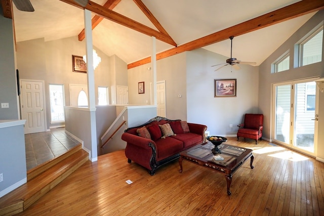 living room featuring hardwood / wood-style flooring, high vaulted ceiling, beamed ceiling, and plenty of natural light