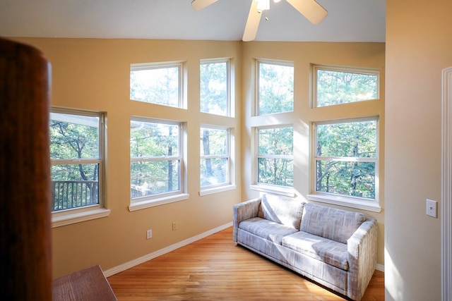 living area with vaulted ceiling, light wood-type flooring, and ceiling fan