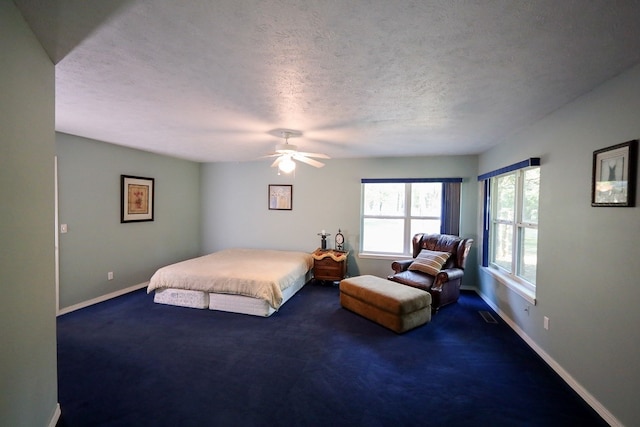 bedroom featuring a textured ceiling, carpet floors, and ceiling fan