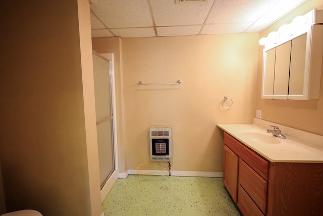 bathroom with a shower with door, vanity, a drop ceiling, and heating unit