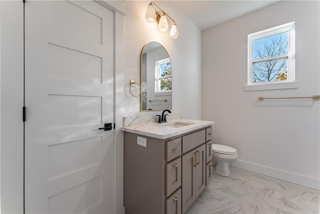 bathroom featuring toilet, marble finish floor, baseboards, and vanity