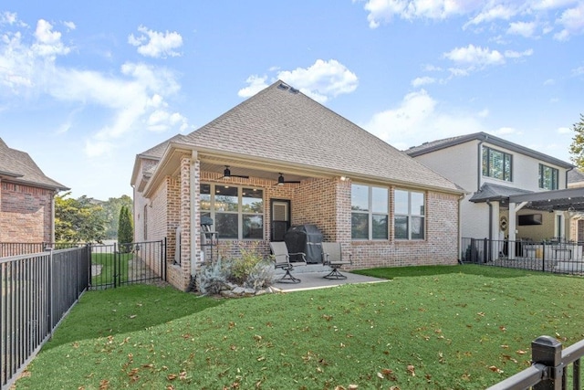 back of property featuring ceiling fan, a lawn, and a patio area