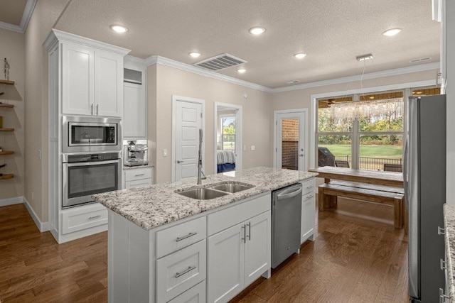 kitchen with appliances with stainless steel finishes, a textured ceiling, dark hardwood / wood-style floors, and white cabinets