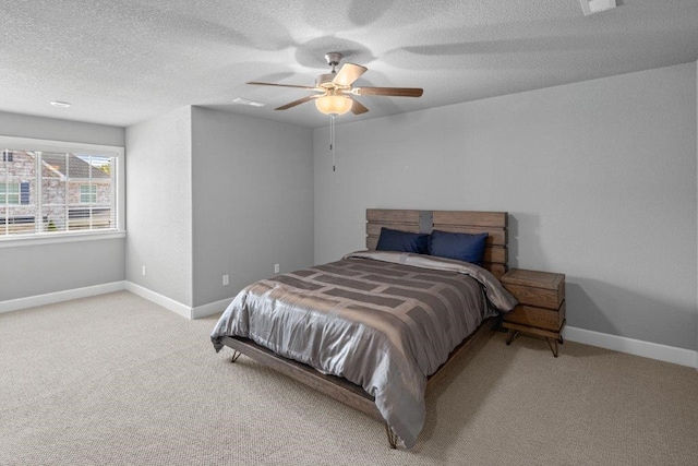 carpeted bedroom featuring ceiling fan and a textured ceiling