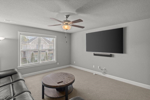 unfurnished room featuring ceiling fan, light colored carpet, and a textured ceiling