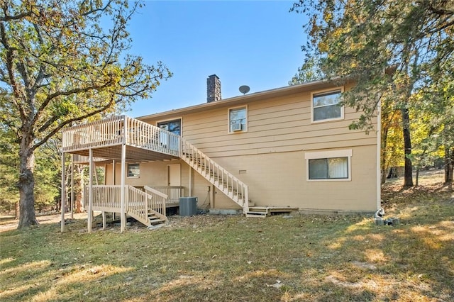 rear view of house featuring a yard, central air condition unit, and a wooden deck