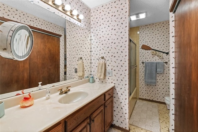 full bathroom featuring vanity, shower / bath combination with glass door, tile patterned floors, toilet, and a textured ceiling