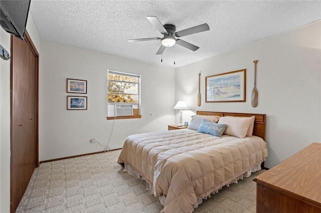 bedroom featuring light carpet, cooling unit, ceiling fan, a textured ceiling, and a closet