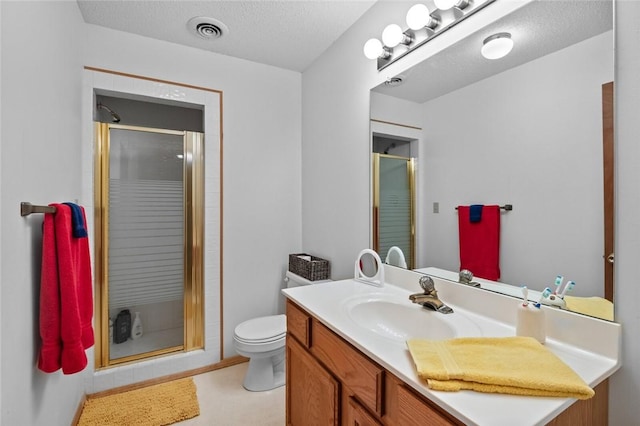 bathroom with vanity, a textured ceiling, toilet, and walk in shower