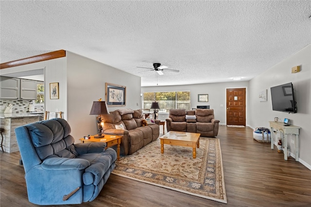 living room featuring ceiling fan, dark hardwood / wood-style flooring, and a textured ceiling