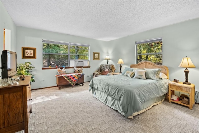 carpeted bedroom featuring cooling unit, a textured ceiling, and multiple windows