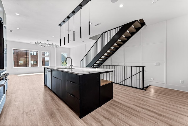 kitchen featuring sink, a large island, pendant lighting, light hardwood / wood-style flooring, and dishwasher