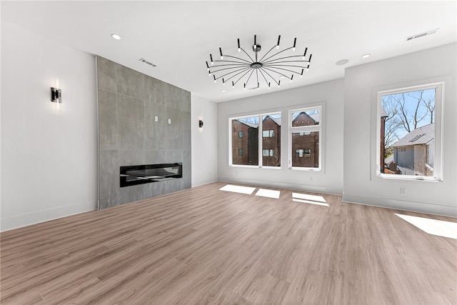 unfurnished living room featuring a fireplace and light hardwood / wood-style flooring