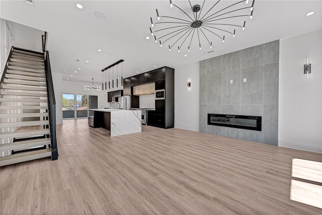 unfurnished living room with a fireplace, light hardwood / wood-style flooring, and sink