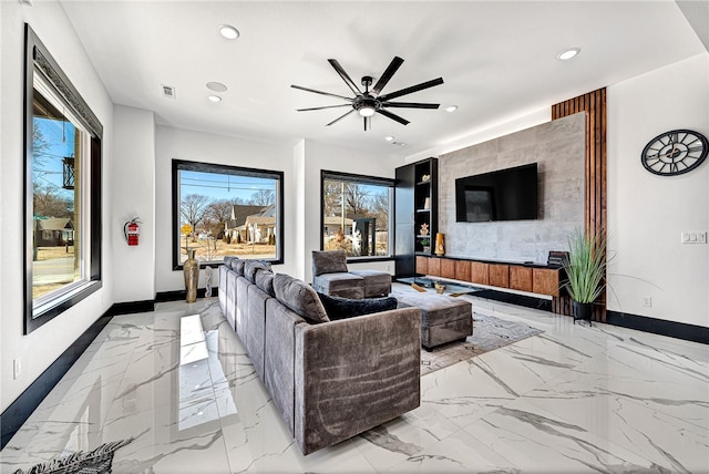 living room featuring a healthy amount of sunlight and ceiling fan