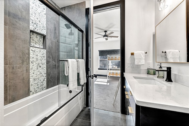 bathroom featuring tile patterned flooring, combined bath / shower with glass door, vanity, and ceiling fan