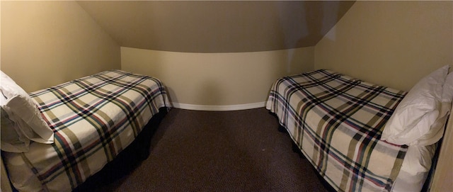 bedroom with dark colored carpet and vaulted ceiling