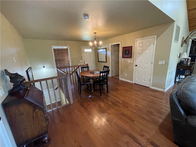 dining area with a notable chandelier and dark hardwood / wood-style floors