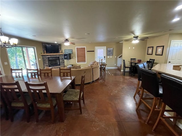 471 Mcphearson Ter, Calico Rock, AR 72519 - dining area with dark tile patterned flooring, baseboards, ceiling fan with notable chandelier, and a stone fireplace
