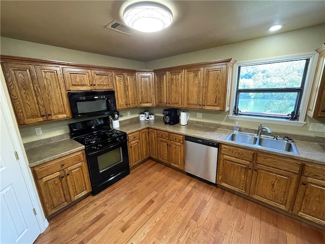 kitchen featuring light hardwood / wood-style floors, sink, and black appliances