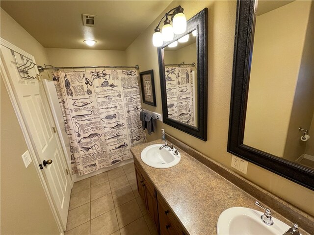 bathroom featuring tile patterned flooring, walk in shower, and vanity