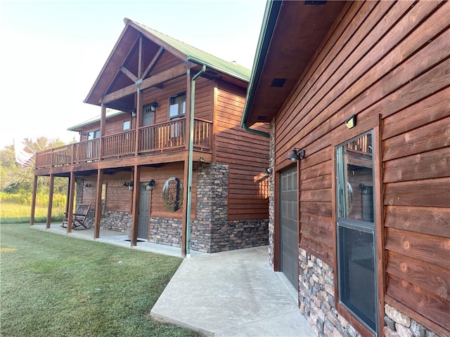 view of property exterior with a lawn and a patio area