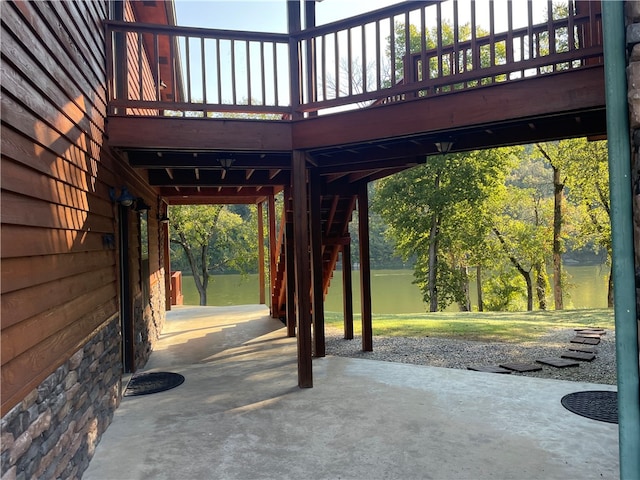 view of patio featuring a deck with water view