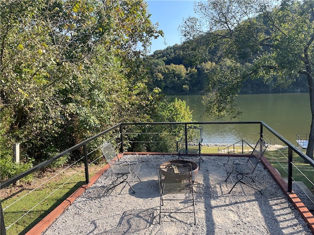 view of patio with an outdoor fire pit and a water view